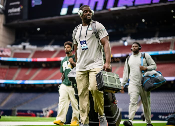 Dolphins football communications manager Renzo Sheppard walks on a field before a game.
